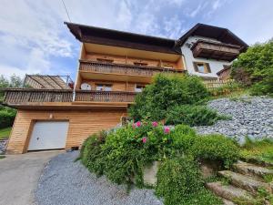 ein Haus mit einem Balkon an der Seite in der Unterkunft Ferienwohnungen MONFREDA Made for better days in Drobollach am Faakersee