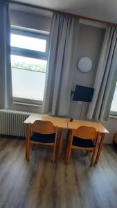 a desk and two chairs in a room with a window at DEULA Witzenhausen GmbH in Witzenhausen