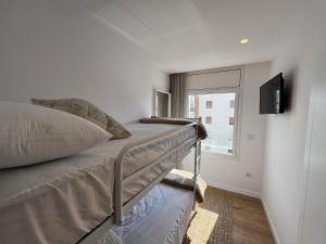 a bedroom with a bed and a tv on a wall at Alexandra 29 in Roses