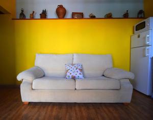 a white couch in a room with a yellow wall at Casa Goliath in Isora