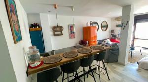 a kitchen with a bar with stools in a room at The funny Tuna in Zahara de los Atunes +14 photos