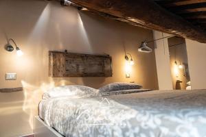 a bedroom with a bed with lights on the wall at Biciclo' Ferrara Città in Ferrara