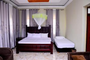 a bedroom with two beds and a chandelier at Peniel Beach Hotel in Entebbe