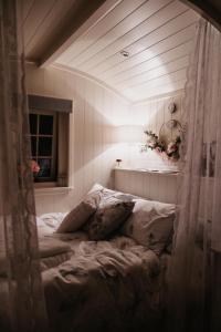 a bed in a room with a window at The Dragonfly Shepherds Hut in Colchester