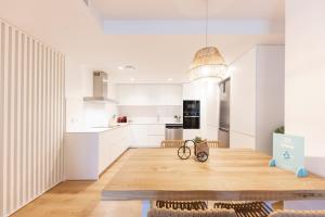 eine Küche und ein Esszimmer mit einem Holztisch in der Unterkunft Bravissimo Sirenes, 2-bedroom apartment in Girona