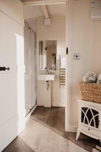 a bathroom with a sink and a mirror at The Dragonfly Shepherds Hut in Colchester