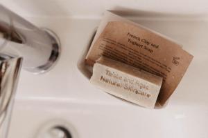 a book is sitting on top of a sink at The Dragonfly Shepherds Hut in Colchester