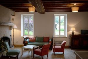 a living room with a couch and chairs and a fireplace at gîte du château in La Bussière