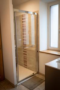 een glazen douche in een badkamer met een raam bij gîte du château in La Bussière