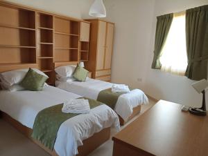 um quarto de hotel com duas camas e uma mesa em 3 Bedroom Air-conditioned Apartment with Roof Terrace - Ample Parking em Naxxar