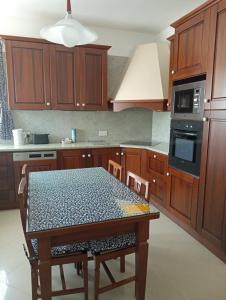 uma cozinha com uma mesa e um fogão forno superior em 3 Bedroom Air-conditioned Apartment with Roof Terrace - Ample Parking em Naxxar