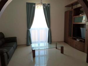 a living room with a glass table in front of a window at 3 Bed Modern Air-conditioned Apartment with Roof Terrace - Ample Parking in Naxxar