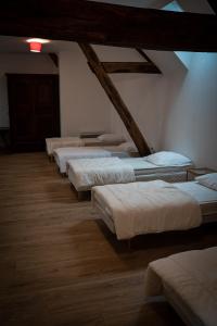 a row of beds lined up in a room at gîte du château in La Bussière
