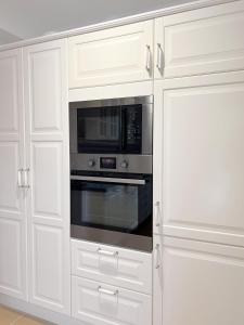 a kitchen with white cabinets and a microwave at Villa Parque Mirador in Playa de Santiago