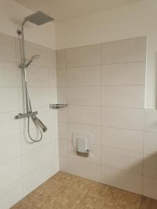 een douche in een badkamer met witte tegels bij Hafenkoje Anita in Zinnowitz
