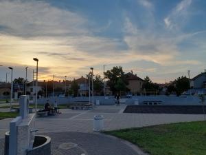 a group of people sitting on benches in a park at Apartman Stevan in Pirot