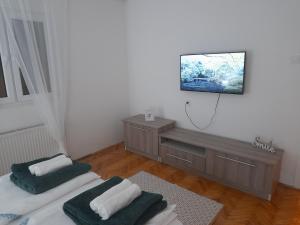 a room with two beds and a tv on the wall at Apartman Stevan in Pirot