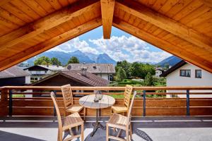 um pátio com uma mesa e cadeiras numa varanda em Chalet Sunshine em Garmisch-Partenkirchen