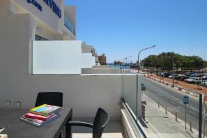 balkon ze stołem, krzesłami i ulicą w obiekcie Phaedrus Living - Seaside Luxury Flat Harbour 109 w Pafos