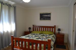- une chambre avec un lit, une commode et une fenêtre dans l'établissement Barefoot Bungalow, à Hat Head