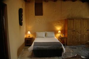 a bedroom with a large bed with two night stands at Karoo Pred-a-tours/Cat Conservation Trust in Cradock