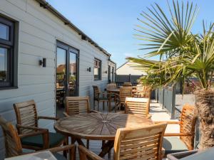 d'une terrasse avec une table et des chaises en bois. dans l'établissement Chalet 3, à Ganton