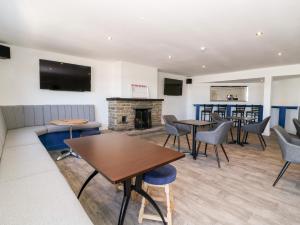 a living room with tables and chairs and a fireplace at Chalet 1 in Ganton