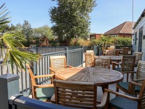 d'une terrasse avec une table, des chaises et une clôture. dans l'établissement Chalet 1, à Ganton