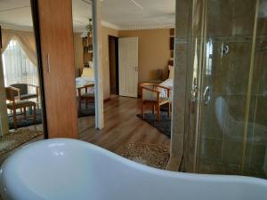 uma casa de banho com banheira e um quarto em Bayside guesthouse em East London