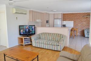 a living room with a couch and a tv at Beach Retreat in South West Rocks
