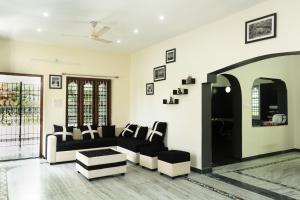 ein Wohnzimmer mit einem Sofa und einem Tisch in der Unterkunft The Mahizh Home in Mahabalipuram