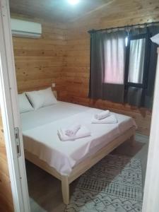 a bed in a wooden room with towels on it at Sea garden apart in Demre