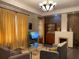 a living room with a television and a fireplace at Old City Lux in Baku