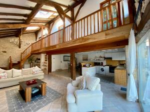 a large living room with a staircase and a kitchen at Anahata Gite in Constant