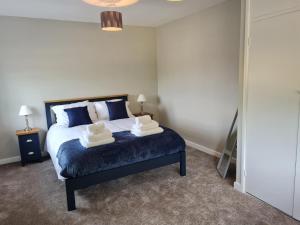 1 dormitorio con 1 cama con 2 toallas en The Farmhouse - Linton Horseheath, en Linton
