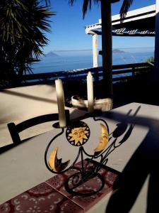 un candelabro con dos velas sobre una mesa en Casa Vacanze sul mare, en Malfa