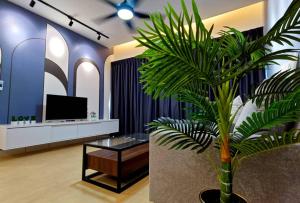 eine Palme in einer Lobby mit einem TV in der Unterkunft Residensi Lili by James NEARBY KILA, KILA 2, PUTRAJAYA, CYBERJAYA in Nilai