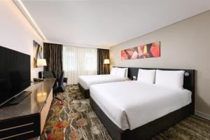 ein Hotelzimmer mit 2 Betten und einem Flachbild-TV in der Unterkunft Holiday Inn Perth City Centre, an IHG Hotel in Perth