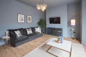 a living room with a black couch and a table at Host & Stay - Parkside Villa in Harrogate