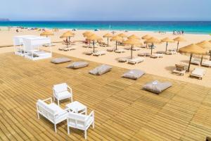 uma vista sobre uma praia com cadeiras e guarda-sóis em Vila Baleira Suites em Porto Santo