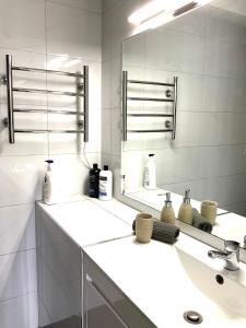 uma casa de banho branca com um lavatório e um espelho em Namely Manly em Sidney