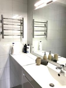 Un baño blanco con lavabo y espejo. en Namely Manly, en Sídney