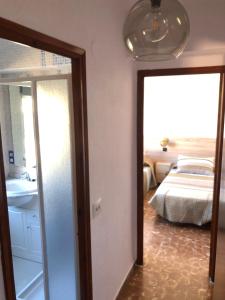 um quarto com um espelho e um quarto com uma cama em APARTAMENTO KORINTO em Benicàssim