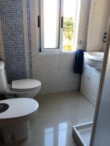 uma casa de banho com um WC, um lavatório e uma janela em APARTAMENTO KORINTO em Benicàssim