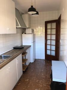 uma cozinha com electrodomésticos brancos e piso em azulejo em APARTAMENTO KORINTO em Benicàssim