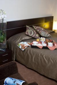 ein Hotelzimmer mit einem Bett mit Essen drauf in der Unterkunft Logis Hotel Restaurant Le Bellevue in Prats-de-Mollo-la-Preste