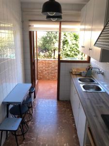 uma cozinha com um lavatório e uma mesa com cadeiras em APARTAMENTO KORINTO em Benicàssim