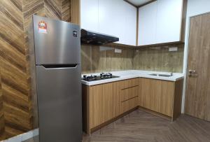 eine Küche mit einem Kühlschrank aus Edelstahl und einer Spüle in der Unterkunft Residensi Lili by James NEARBY KILA, KILA 2, PUTRAJAYA, CYBERJAYA in Nilai