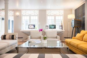 a living room with two couches and a glass table at LUX* Saint Gilles Resort in Saint-Gilles-les-Bains