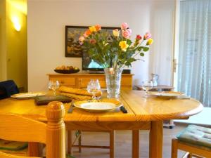 uma mesa de madeira com um vaso de flores em Appartement Bagnères-de-Luchon, 2 pièces, 4 personnes - FR-1-313-123 em Luchon